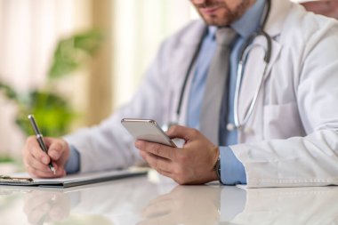 Ofisindeki cep telefonunu kullanarak doktoru kapat. Sağlık ve insanlar konsepti.