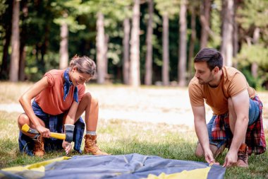 Yürüyüşten sonra çadır kuran çift. Ormanın tadını çıkarıyorum. İnsanlar, doğa ve yaşam tarzı kavramı.