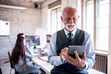 Ofiste tablet kullanan kıdemli iş kadını.. 