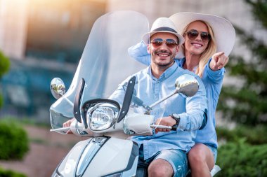 Şehirde motosikletle gezen mutlu çift.