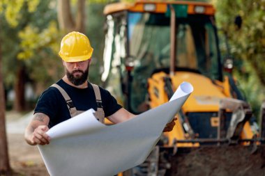 İnşaat alanında çalışan bir mimarın portresi, yeni bir proje arıyor.