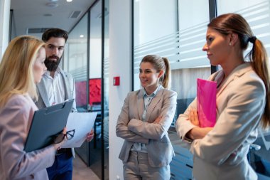 Genç çekici iş adamları modern ofiste çalışıyor ve yeni projeler hakkında konuşuyorlar..