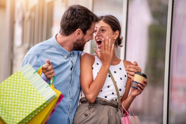 Alışveriş yaptıktan sonra alışveriş torbalarıyla mutlu bir çiftin portresi..