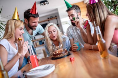 Bir grup arkadaş evde doğum gününü kutluyor ve eğleniyorlar. İnsanlar, kutlama, keyif ve yaşam tarzı konsepti..