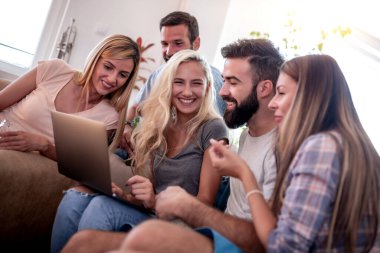 Bir grup arkadaş birlikte vakit geçirip laptopa bakıyorlar..