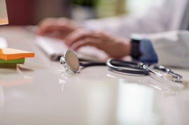 Ofiste çalışan doktor. Steteskop masada. Kapatın..