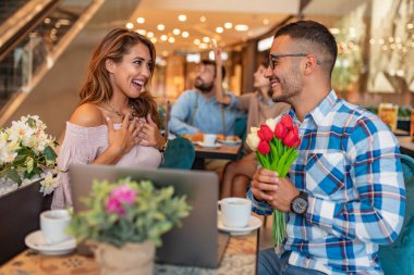 Çift kahve içer, laptop kullanırken kafede eğlenir. İnsanlar, aşk ve yaşam tarzı konsepti..