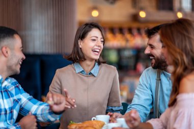 Bir grup mutlu arkadaş restoranda kahvaltı edip kahve içiyorlar. İnsanlar, eğlence, arkadaşlık ve iletişim konsepti.