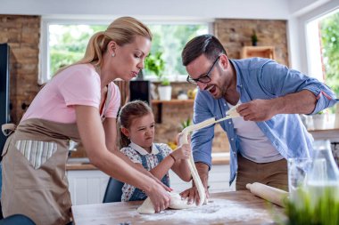 Genç, neşeli aile mutfaklarında kurabiye yapıyor..