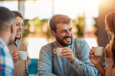 Arkadaşlar restoranda harika vakit geçiriyorlar. Bir kafede oturan bir grup genç..