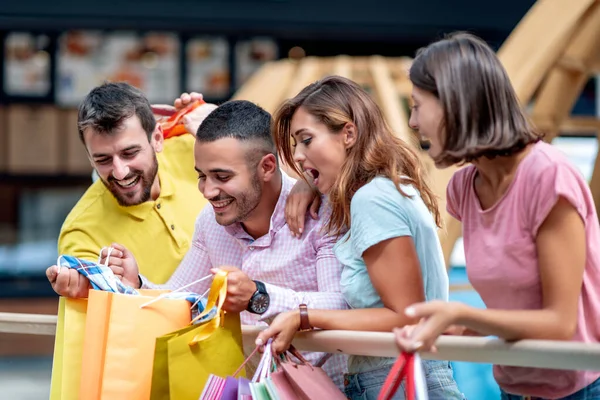 Group of friends in the city after shopping holding shopping bags and walking through city.