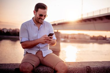 Genç adam cep telefonuna bakıyor..