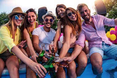 Arkadaşlarla havuz partisinin tadını çıkarıyorum. Bir grup insan havuz başında parti veriyor..