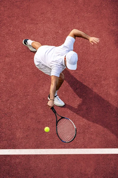 Sport. Top view of male tennis player hitting ball with racket.