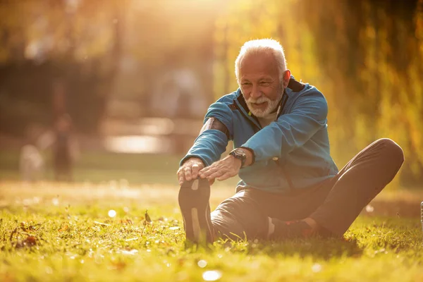 Портрет Счастливого Пожилого Мужчины Растягивающего Ноги Парке — стоковое фото