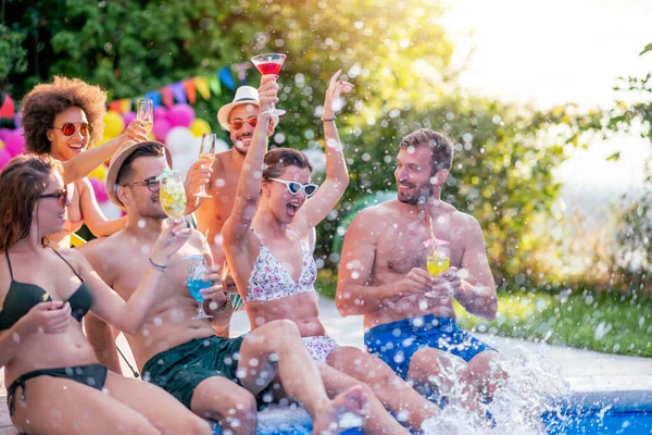 Enjoying pool party with friends. Group of friends having party by swimming pool.