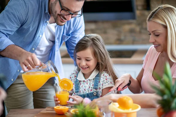 Ευτυχισμένη Οικογένεια Στην Κουζίνα Ετοιμάζοντας Φρέσκο Χυμό Πορτοκαλιού — Φωτογραφία Αρχείου