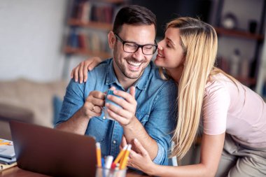 Evde bir çift, online alışveriş için dizüstü bilgisayar kullanıyorlar..