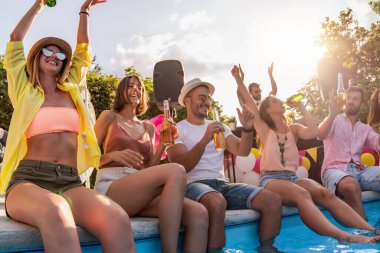 Arkadaşlarla havuz partisinin tadını çıkarıyorum. Bir grup arkadaş havuz başında parti veriyorlar..