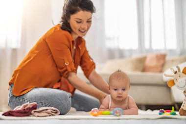 Bebek masajı. Evde güzel bir bebeğe masaj yapan genç bir kadın..