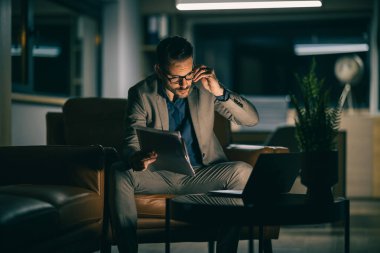 Ekonomik sorunlar ve iş için zor zamanlar. Düşünceli ve endişeli ifadesiyle dizüstü bilgisayarı izleyen bir iş adamı. Yoğun çalışma günü.