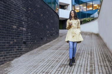 Şehirde işe giderken elinde kahve tutan başarılı bir iş kadınının portresi. İş kadını işe gidiyor..