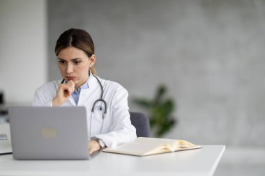 Kadın doktor portresi klinikte online bir hastayla konuşuyor. Yurtiçi sağlık tedavisi için online danışmanlık yapıyor. O, yoğun bir iş gününden sonra baş ağrısı çekiyor..