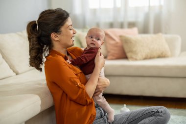 Sevgi dolu anne, yeni doğmuş bebeğini evde taşıyor. Anne ve bebeğin sevgisi. Aile evde..