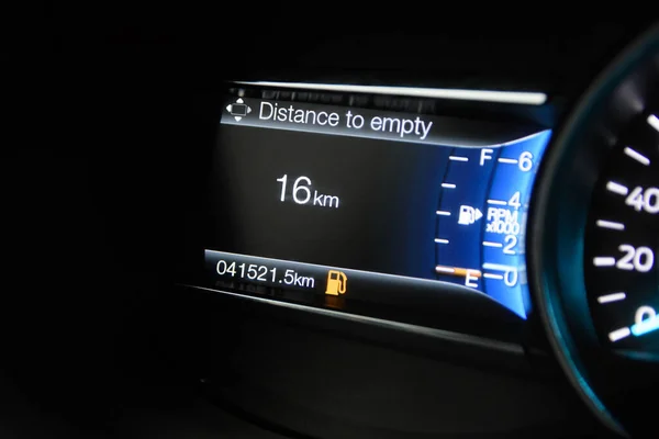 The on-board computer of a modern car with color infographics shows the travel distance with the current amount of fuel in the tank. Color multi-function car display