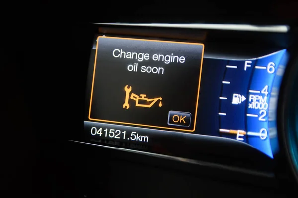 The on-board computer of a modern car with color infographics warns the driver about changing engine oil soon. Color multi-function car display