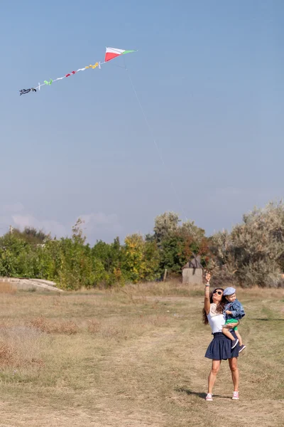 Jeune mère et son fils jouer avec cerf-volant — Photo