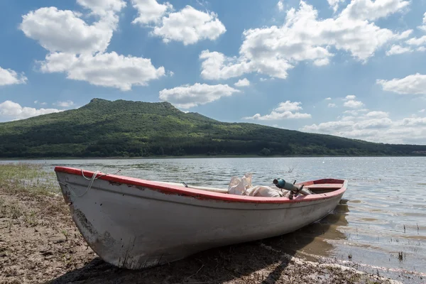 Barco de pesca solitario en el lago con cielo nublado — Foto de Stock