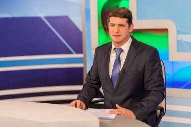 Televizyon stüdyosunda erkek sunucu. Canlı yayın.