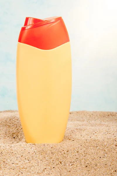 Suntan plastic bottle on the sand — Stock Photo, Image