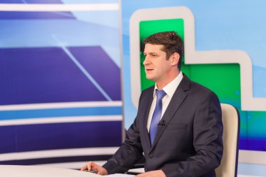 Televizyon stüdyosunda erkek sunucu. Canlı yayın.