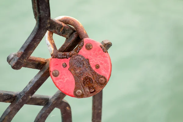 Nahaufnahme eines alten rostigen Vorhängeschlosses auf der Brücke — Stockfoto