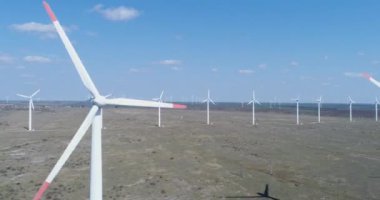 Yel değirmeni çiftliğinin 4K hava görüntüsü. Modern rüzgar türbinleri. Rüzgar en temiz, yenilenebilir enerji kaynağıdır.. 