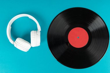 Beyaz kablosuz kulaklıklar ve eski plaklar. Müzik konsepti. Rretro ses sistemi