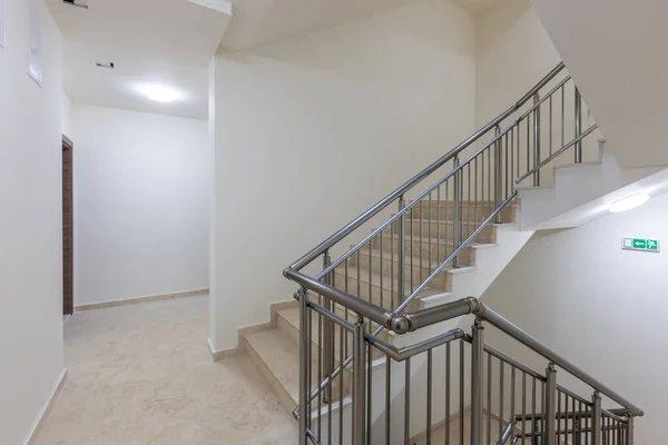 Modern stair case between floors. Stairs with metallic rail  in modern building