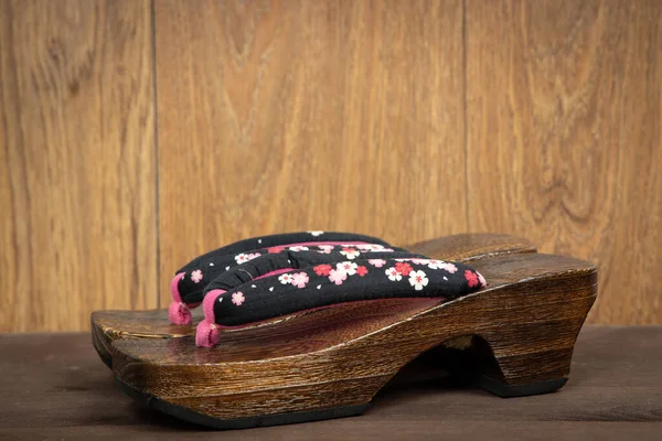 木の背景に日本の伝統的な下駄のサンダル 下駄と呼ばれる日本の伝統的なアジアの木の履物 — ストック写真