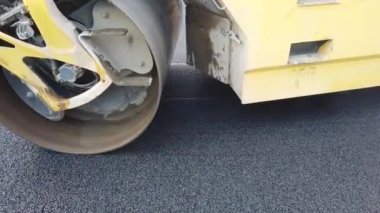 Asfalt kaldırımındaki ağır titreşimli paten sıkıştırıcıyı kapat yol onarımı için çalışır..
