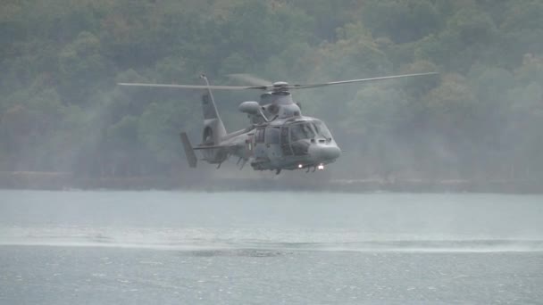 救助任務の間 水の上に低い位置にホバリング軍 救助ヘリコプター 低ホバーターンを実行する救助ヘリコプター スローモーション — ストック動画