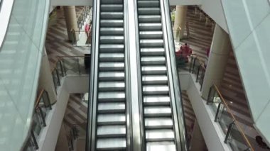 Alışveriş merkezinde boş merdivenlerin yukarı aşağı koşuşunun 4K görüntüsü. Modern yürüyen merdiven.