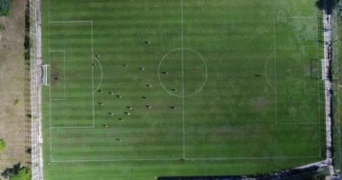 Futbol sahasının alt tarafı. Hava futbol maçı. İki takım top view oynuyor. Çocuklar futbol oynuyor..