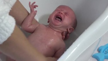 Anne yeni doğan bebeği için banyo yapıyor. Bebek banyosu zamanı