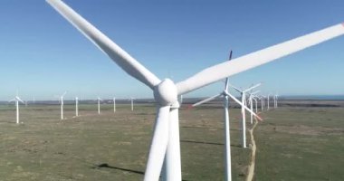 Yel değirmeni çiftliğinin 4K hava görüntüsü. Modern rüzgar türbinleri. Rüzgar en temiz, yenilenebilir enerji kaynağıdır.. 