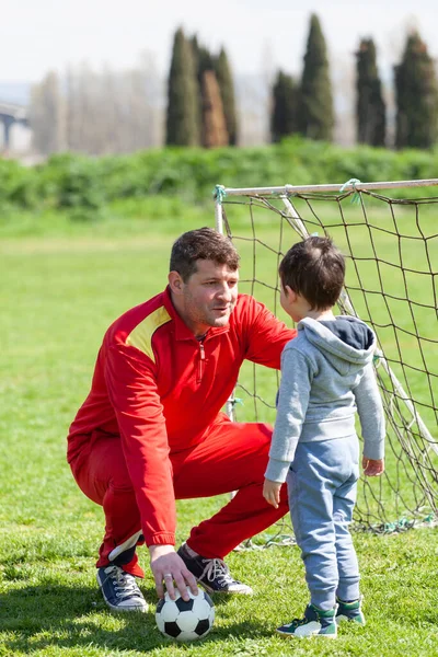彼の小さな息子と父は公園でサッカーをしていた 父は息子に教える — ストック写真