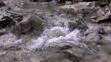 Nehir şelalesi kayaları akar. Dağ nehri. Nehir deresi deresi. Yavaş çekim.