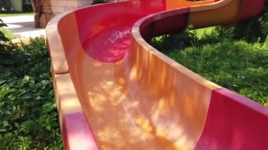 Çocuk yaz tatilinde su parkında kayıyor. Mutlu çocuk su kaydırağından kayıyor.