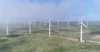 Yel değirmeni çiftliğinin 4K hava görüntüsü. Modern rüzgar türbinleri. Rüzgar en temiz, yenilenebilir enerji kaynağıdır.. 